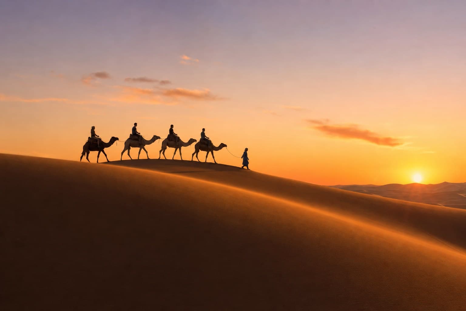 Travellers on a camel trek across the Sahara sand